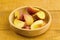 Fresh chopped peaches in a bowl on wooden background