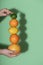 Fresh citrus fruits stack in hand. Summer fruits column