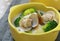 Fresh clams milk potato soup in green bowl on tablecloth