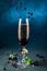 Fresh cocktail with champagne, currants and mint in wineglass on dark blue background. Studio shot of drink in freeze motion