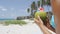 Fresh coconut water on Caribbean beach - vacation woman holding tropical fruit