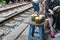 Fresh coconuts served by a railway cafe. People drink coffee or walking on railways waiting for train to arrive on railway road in