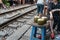 Fresh coconuts served by a railway cafe. People drink coffee or walking on railways waiting for train to arrive on railway road in