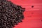 Fresh coffee beans on red background. Dark fresh roast coffee bean on red wood background