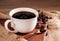 Fresh coffee. A coffee cup or mug lies on a wooden table with roasted coffee beans. Espresso mocha cappuccino barista, top view