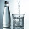 Fresh and cold, pure Water is poured into a glass with bottle. Purified water in a glass on a gray background. Motion freeze