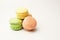 Fresh colored macaroons lie in a heap aside. Meringue on an isolated background with copy space