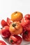 Fresh colorful tomatoes (red, yellow, orange) on white plate with hard shadows on textured background