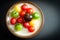 Fresh, colourful red, green, yellow and purple tomatoes served on a rustic dish.