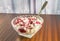 Fresh cottage cheese with strawberry jam in the glass bowl on the table with silver spoon