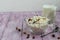 Fresh cottage cheese in a transparent bowl with raisins. In the background is a glass of kefir. Fermented foods. Good bacteria for