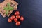 Fresh crackers, tomatoes and basil on a black stone on a table