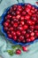 Fresh cranberries in a blue bowl. Ripe berries of Vaccinium macrocarpon, also large cranberry, American cranberry or bearberry.