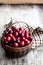Fresh cranberries in small wicker basket on wooden table