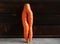 fresh creative carrots in the form of legs on a wooden background