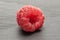 Fresh crimson raspberry on grey stone