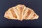 Fresh croissant on a black slate background. Top view