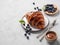 Fresh croissant with chocolate on a white plate on a light background with a blueberries. Delicious homemade breakfast concept