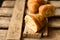 Fresh croissant cut in half with flaky pastry inside visible, on vintage plank wood background,close up