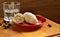 Fresh croissant sprinkled with powdered sugar on a red plate