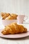 Fresh croissants with cup of coffee, side view.