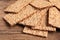 Fresh crunchy crispbreads on wooden table, closeup