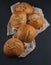 Fresh, crunchy spelt rolls, sourdough with napkin on a dark slate plate kitchen table