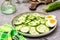 Fresh cucumber salad, boiled chicken eggs and green onions on a plate