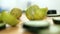 Fresh cucumber slices and halved limes on wooden cutting board