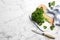 Fresh curly parsley, cutting board and knife on white marble table, flat lay. Space for text