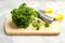 Fresh curly parsley, cutting board and mincing knife on table