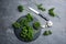 Fresh curly parsley, garlic and knife on grey table, flat lay