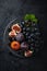 Fresh dark fruits grapes, figs, plum and blackberry on black p