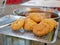 Fresh deep-fried dough Pa Tong Go with sesame seeds on a tray rack ready to be served