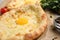 Fresh delicious Adjarian khachapuri on parchment