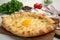 Fresh delicious Adjarian khachapuri on white table, closeup