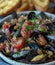 Fresh and delicious mussels cooked with tomato, parsley on a ceramic bowl