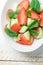 Fresh Detox Summer Salad with Strawberries Green Mint Leaves in White Ceramic Bowl. Plank Wood Table. Top View