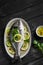 Fresh Dorado fish with lemon, lime and parsley on an oval dish
