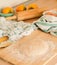 Fresh dough on the board with flour, chequered and striped towel