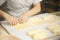 Fresh dough and flour, hands of the cook knead pizza or pie