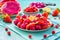 Fresh dragon fruit salad with strawberries, raspberries and start fruit carambola
