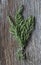 Fresh ecological rosemary bouquet tied with a rope and on an old wooden plank