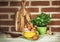 Fresh eggs, green basil and wooden kitchen props on brick wall b