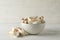 Fresh eringi mushrooms in bowl on white wood background
