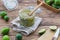 Fresh feijoa jam in a glass jar with a bamboo spoon on the wooden background