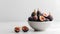 Fresh figs in a bowl on a white background. Copy space.