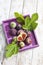 Fresh figs, Ficus carica and leaves, in purple wood tray