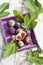 Fresh figs, Ficus carica and leaves, in purple wood tray