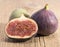 Fresh figs, half and whole on wooden plank, close up. Food photo